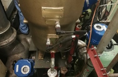 Industrial machinery with pipes and valves, featuring blue components and wiring.