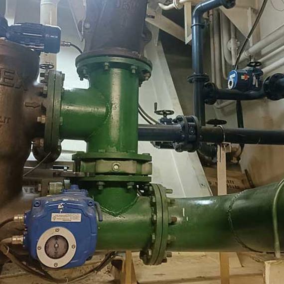Industrial filtration system with green pipes and control valves in a mechanical room.