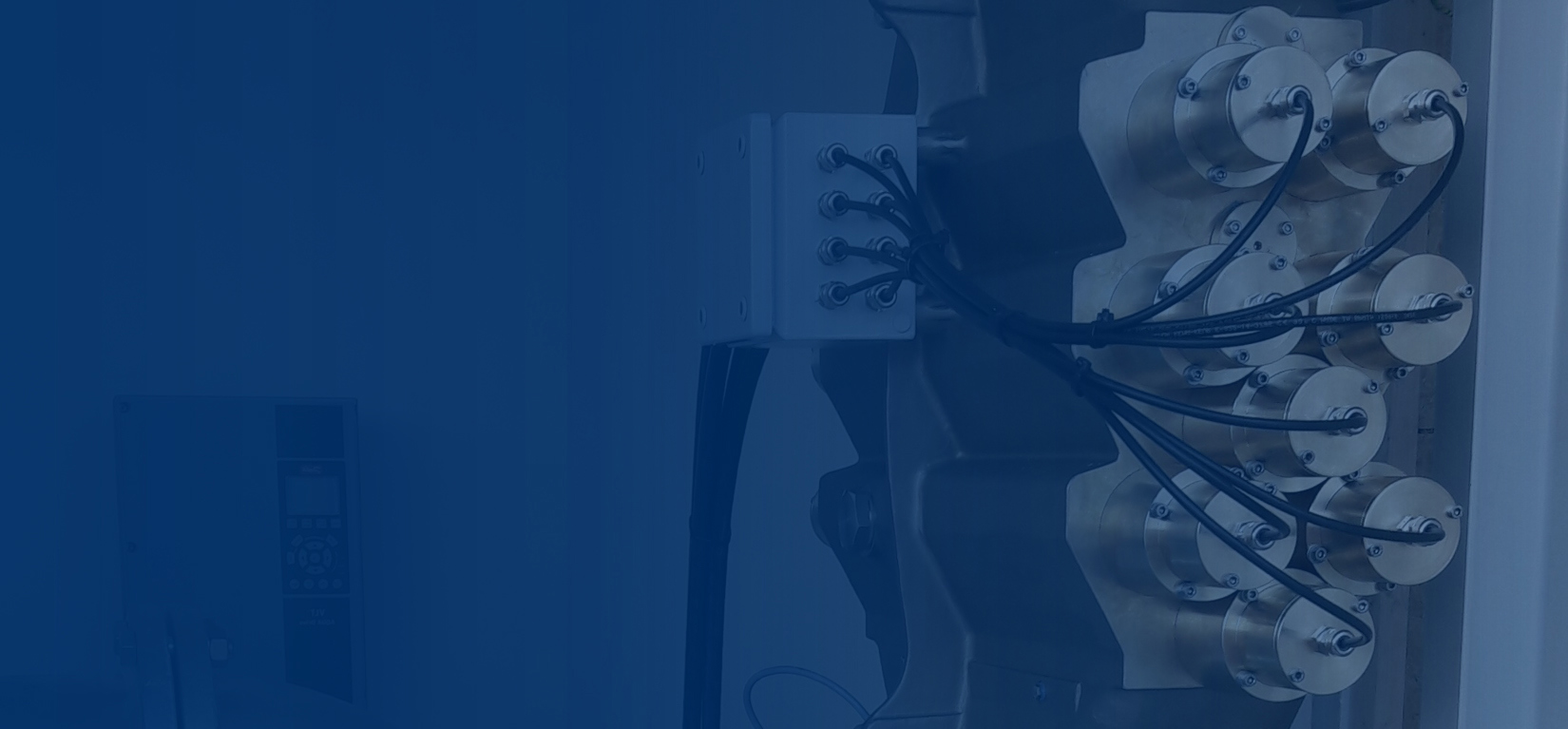 Electrical control unit with multiple cables connected to cylindrical components.