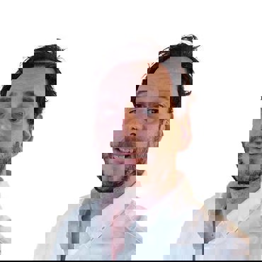 Smiling man in a white shirt against a plain white background.