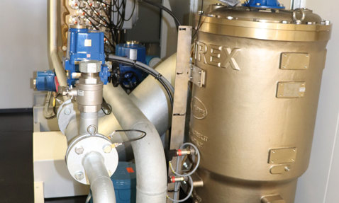 Industrial pump system with pipes and control units in a mechanical room.