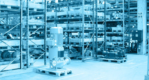 Warehouse with industrial equipment and shelving, including a DESMI vertical pump.
