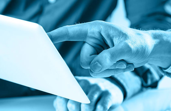 Two people interacting with a tablet in a professional setting.