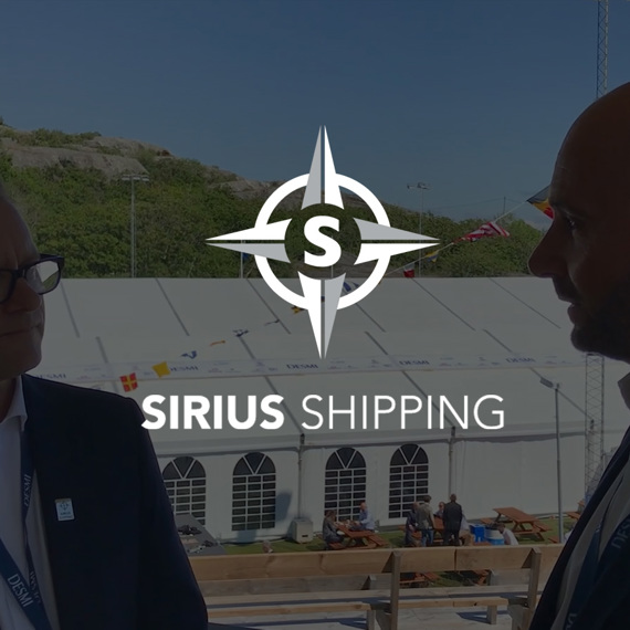 Two men conversing outdoors with Sirius Shipping and DESMI logos visible.