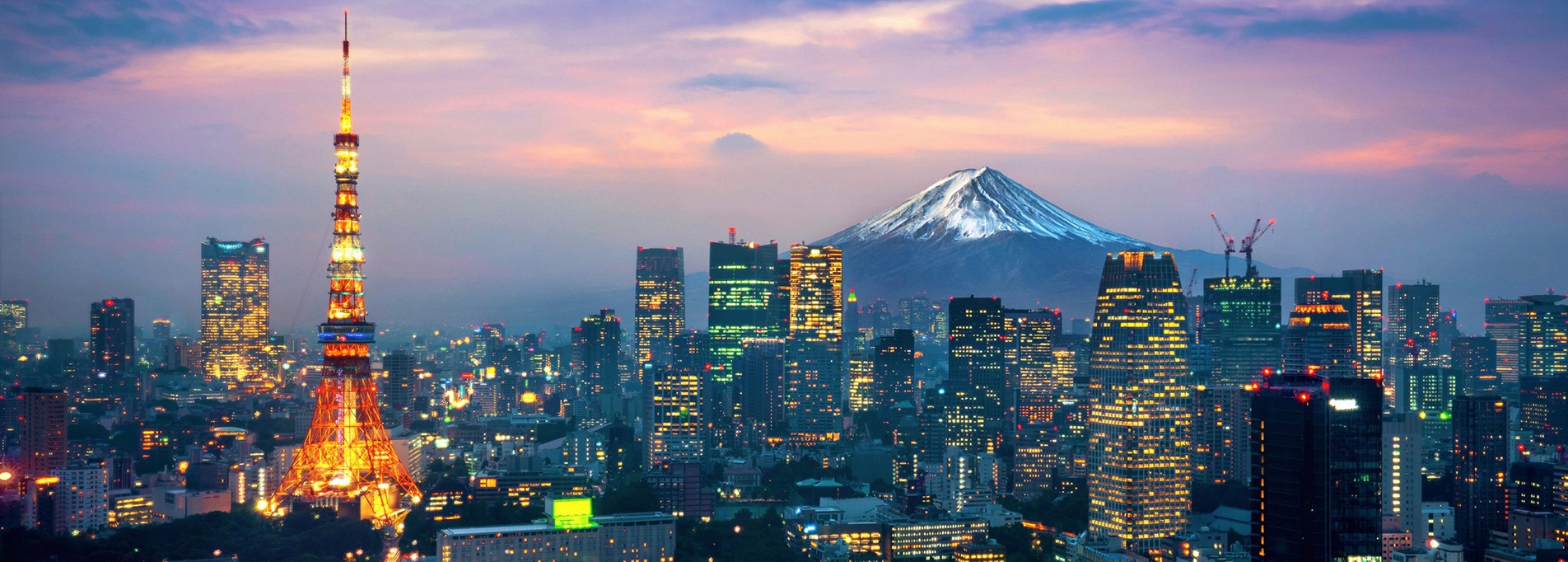 Tokyo skyline at dusk with illuminated Tokyo Tower and Mount Fuji in background.