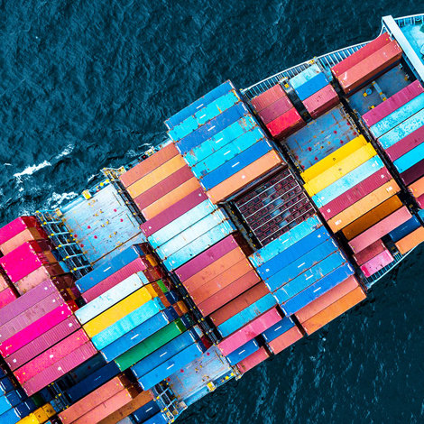 Aerial view of a cargo ship with colorful containers at sea.