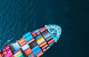 Aerial view of a cargo ship with colorful containers at sea.