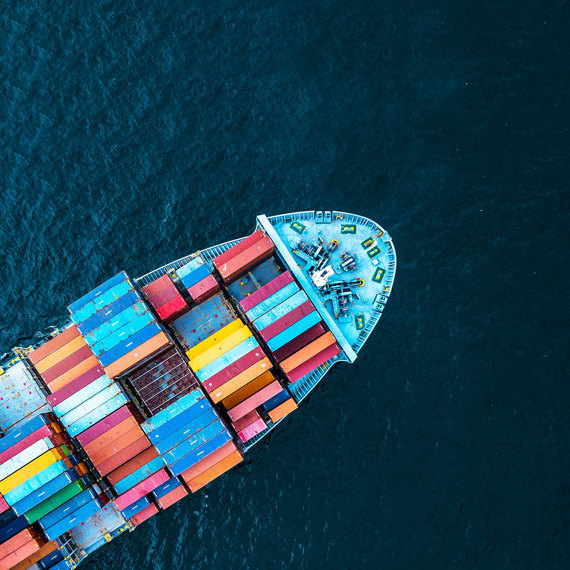 Aerial view of a cargo ship with colorful containers at sea.
