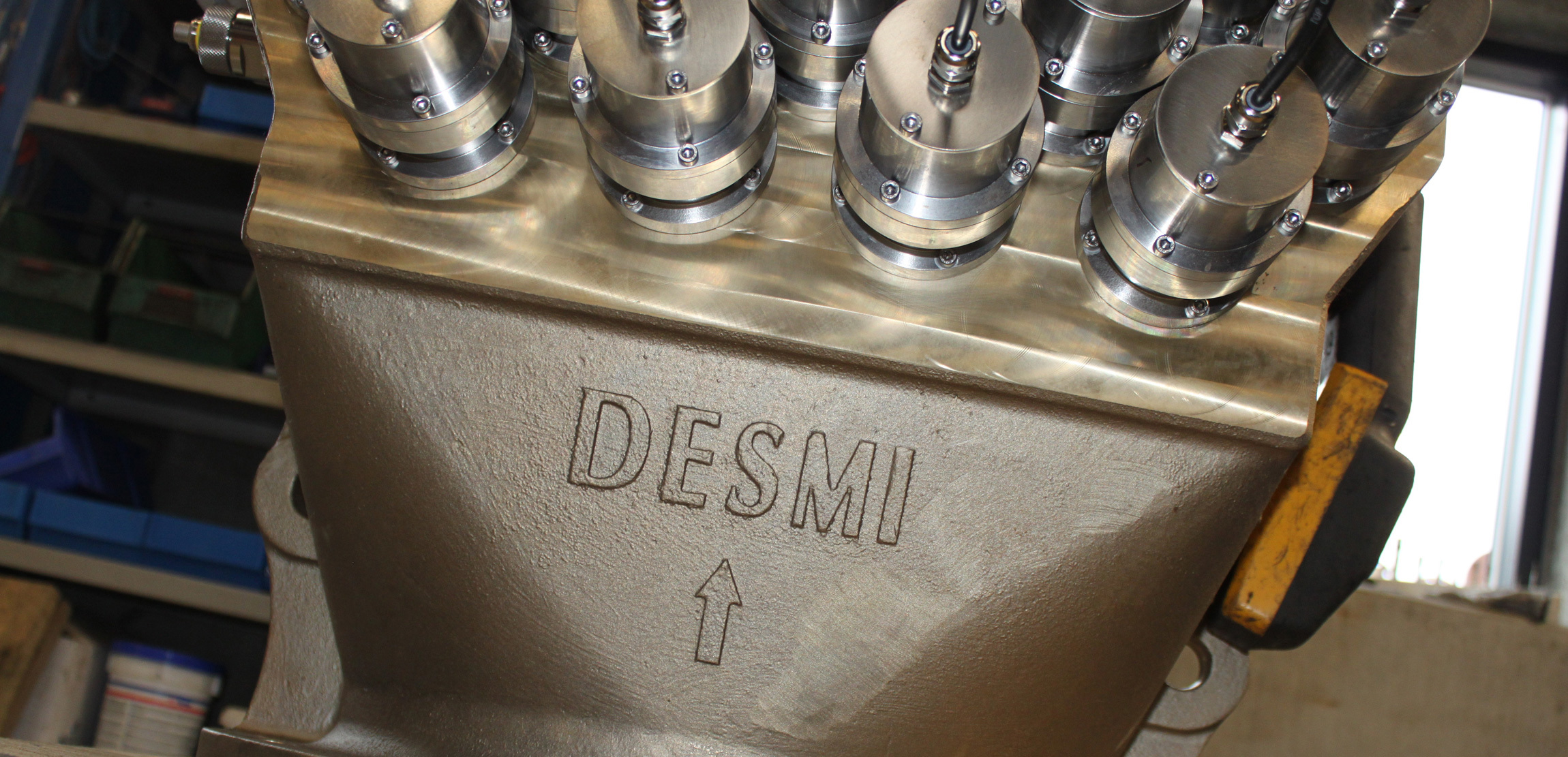 DESMI industrial machinery component with multiple metal connectors for fluid handling.