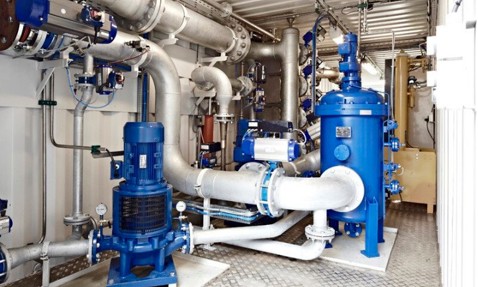 Industrial pump room with DESMI equipment for fluid handling and processing.