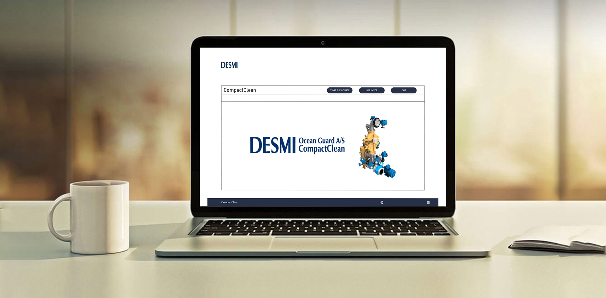 Laptop displaying DESMI Ocean Guard CompactClean system on screen, beside a coffee mug.