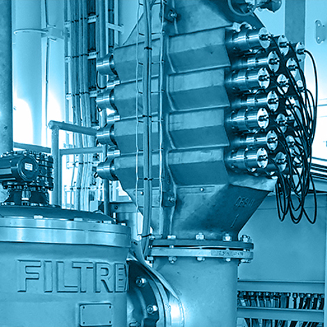 Industrial filtration system in a facility with visible pipes and machinery.