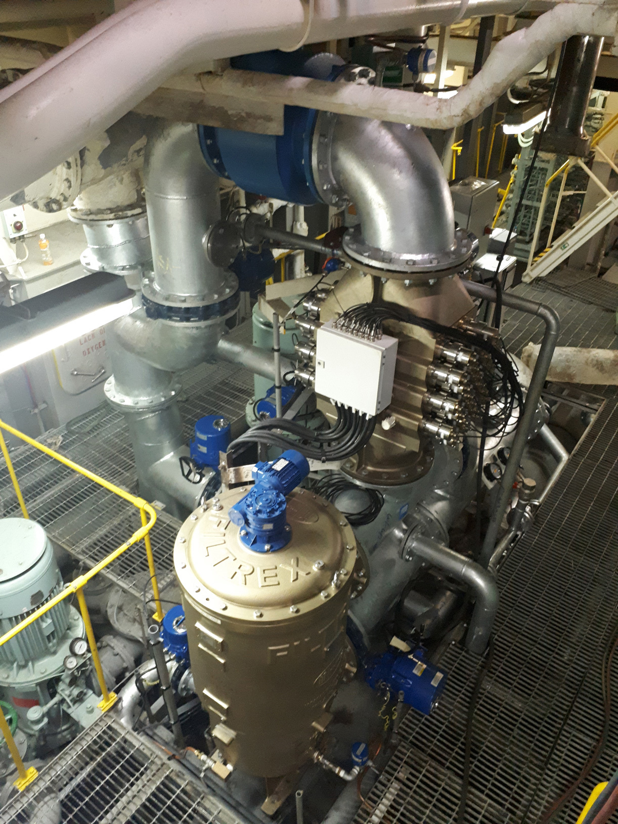 Industrial machinery with pipes and a large Filtrex unit for fluid handling.